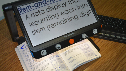 portable  magnifier and book with a refreshable braille display on table top